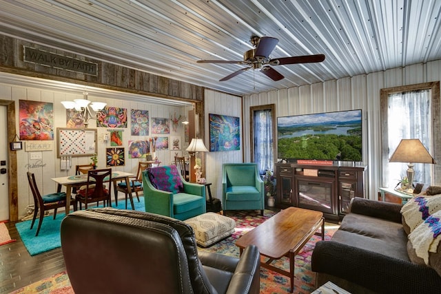 living room with hardwood / wood-style floors and ceiling fan with notable chandelier