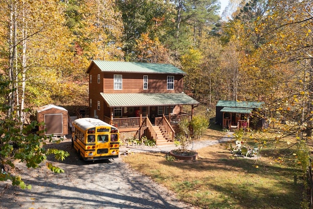 view of front of property featuring a storage shed and a fire pit