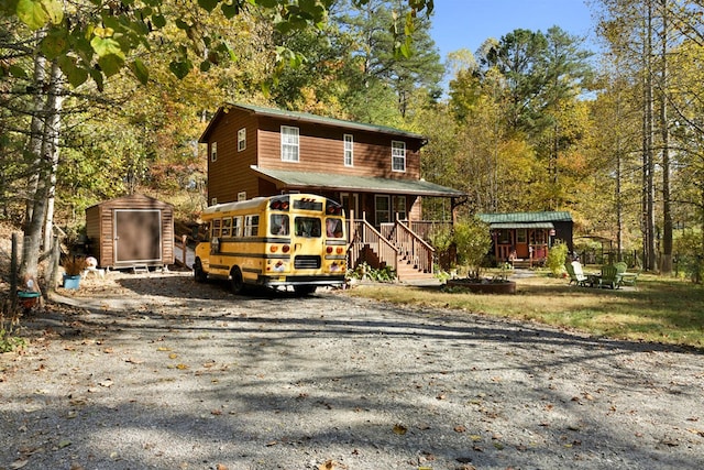 view of front facade featuring covered porch and a storage unit