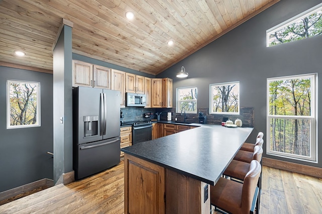 1250 Lost Forest Rd, Ellijay, GA 30536 - kitchen with stainless steel appliances, dark countertops, a sink, wood ceiling, and a peninsula