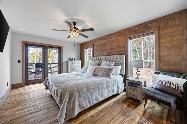 1250 Lost Forest Rd, Ellijay, GA 30536 - bedroom featuring wooden walls, hardwood / wood-style floors, access to exterior, and baseboards
