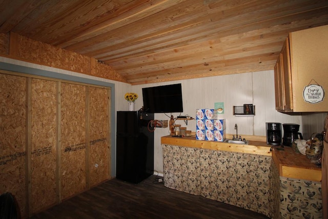 kitchen with black fridge, wooden ceiling, and wooden walls