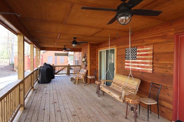 wooden terrace featuring covered porch and a grill