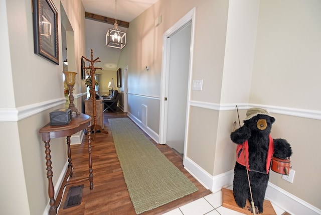 hall featuring hardwood / wood-style floors and a chandelier