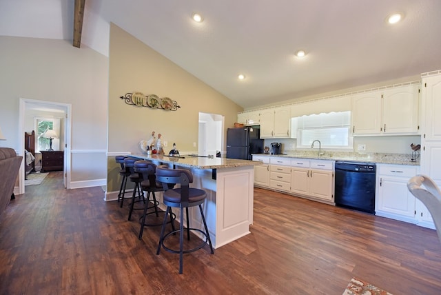 kitchen with black appliances, light stone counters, white cabinets, and dark wood-type flooring