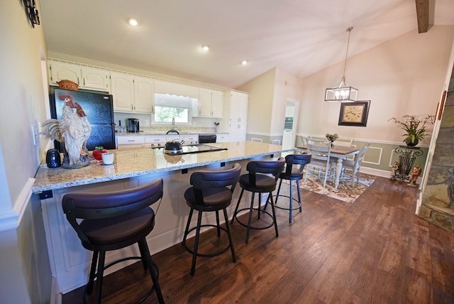 kitchen featuring white cabinets, vaulted ceiling with beams, dark hardwood / wood-style floors, and black appliances