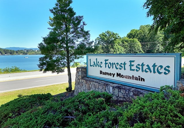 community / neighborhood sign featuring a water and mountain view