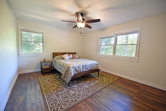 bedroom featuring a textured ceiling, multiple windows, ceiling fan, and dark hardwood / wood-style floors