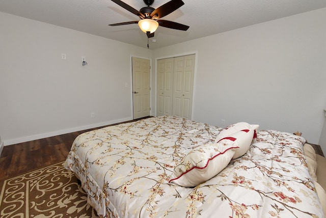 bedroom with ceiling fan, dark hardwood / wood-style floors, a textured ceiling, and a closet