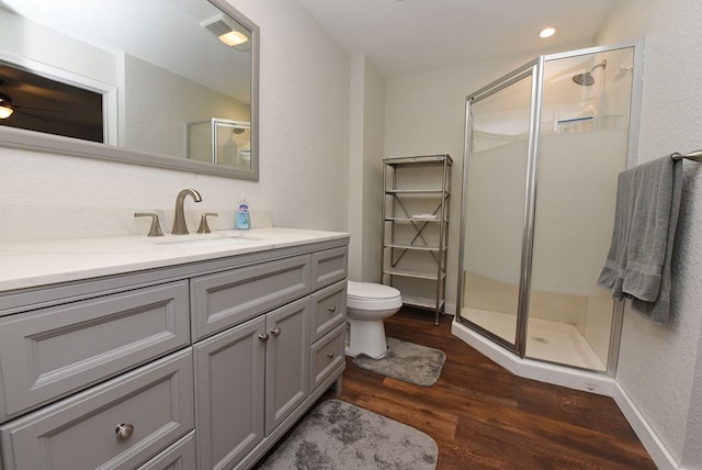 bathroom featuring hardwood / wood-style floors, vanity, and a shower with shower door