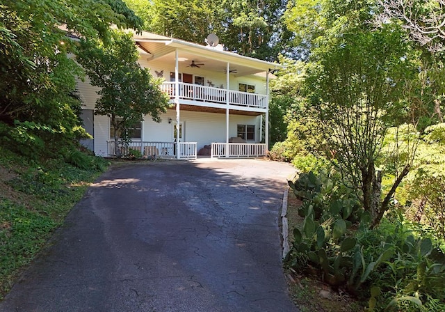 view of front of house featuring a balcony and ceiling fan