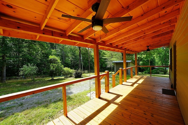 wooden terrace with a shed and a lawn