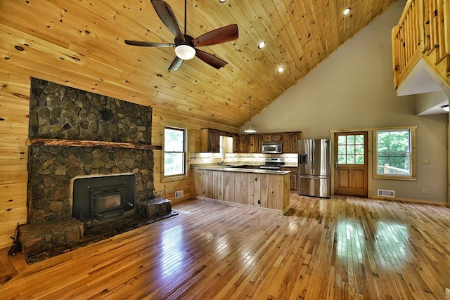 kitchen with stainless steel appliances, kitchen peninsula, light hardwood / wood-style flooring, and wooden ceiling