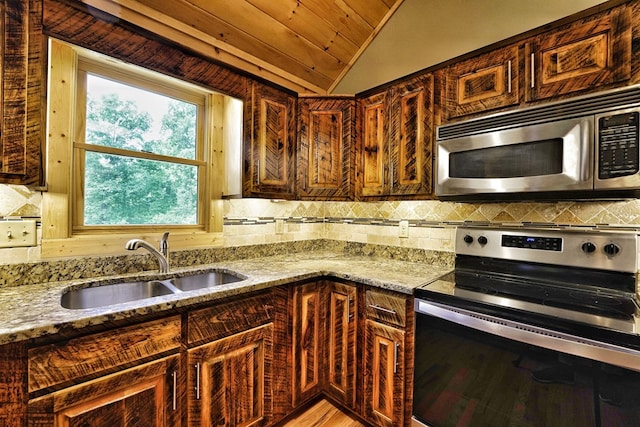 kitchen featuring light stone counters, sink, decorative backsplash, and appliances with stainless steel finishes