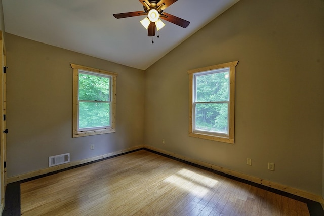 unfurnished room featuring a wealth of natural light, light hardwood / wood-style floors, ceiling fan, and vaulted ceiling