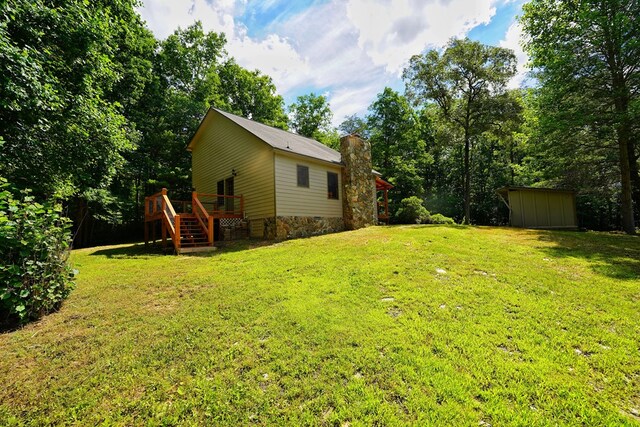 view of yard featuring a wooden deck and a storage shed