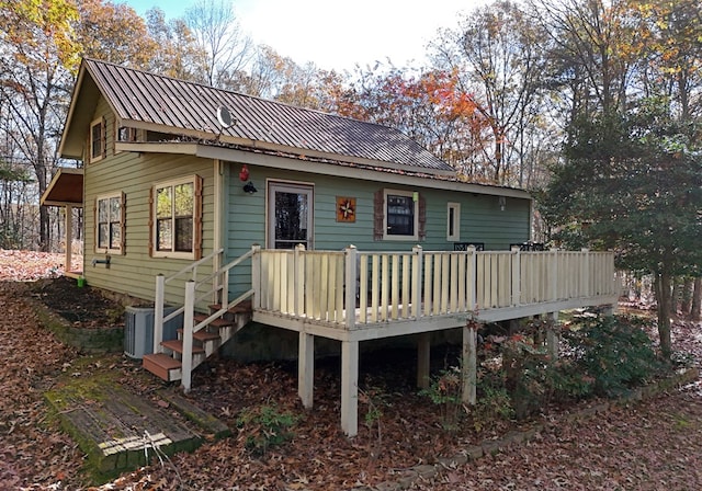 rear view of property featuring central AC and a wooden deck