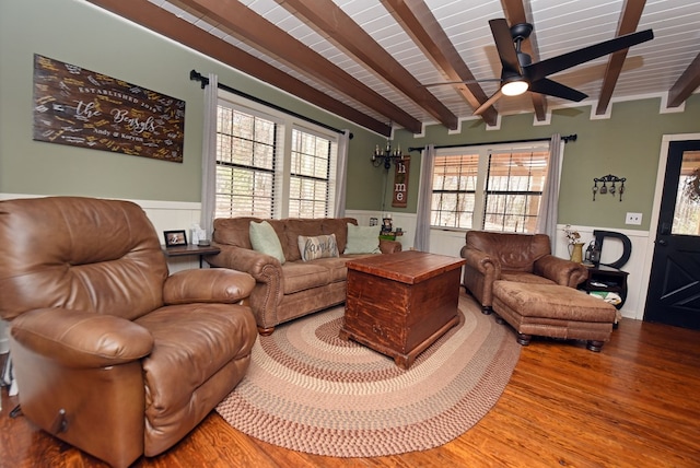 living room with hardwood / wood-style floors, ceiling fan, and beam ceiling