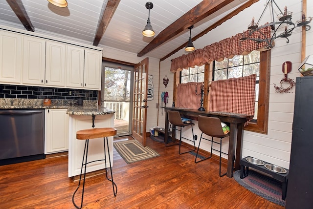 kitchen featuring a healthy amount of sunlight, vaulted ceiling with beams, pendant lighting, and dishwasher