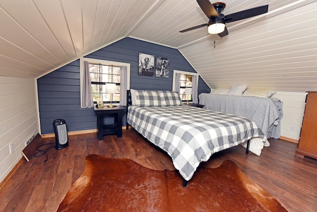 bedroom with wood walls, hardwood / wood-style floors, lofted ceiling, and ceiling fan