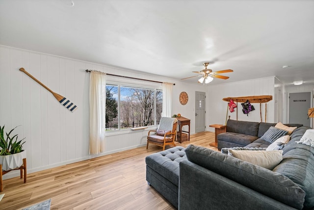 living room featuring wood finished floors, a ceiling fan, and baseboards