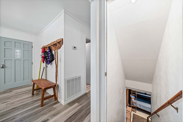 entrance foyer featuring wood finished floors, visible vents, and ornamental molding