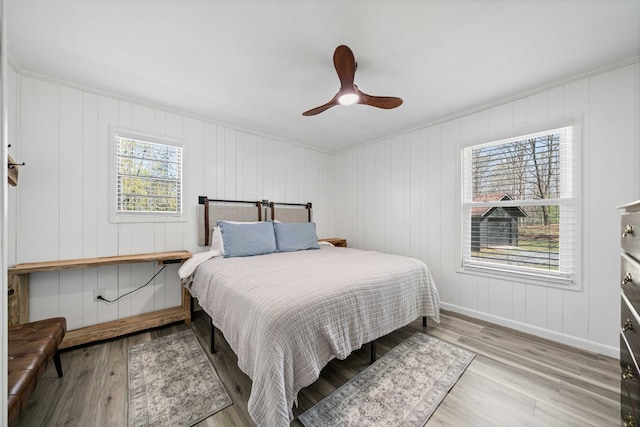 bedroom featuring ceiling fan, baseboards, and wood finished floors