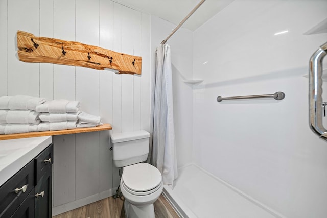 bathroom featuring curtained shower, wood finished floors, toilet, and vanity