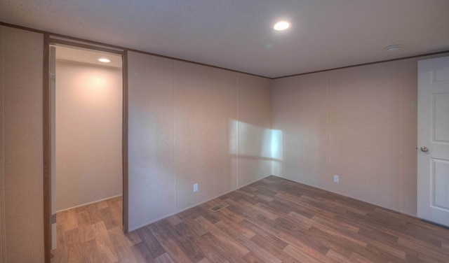 empty room with hardwood / wood-style flooring and a textured ceiling