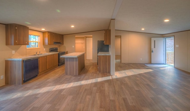 kitchen with a center island, black appliances, vaulted ceiling, and light hardwood / wood-style floors