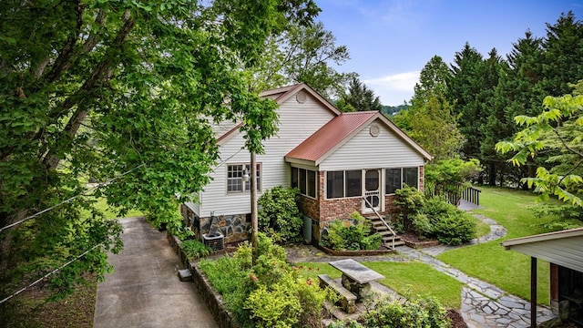 16 Hollow Springs Rd, Blue Ridge, GA 30513 - view of front of home with a sunroom, stairs, a front lawn, and brick siding