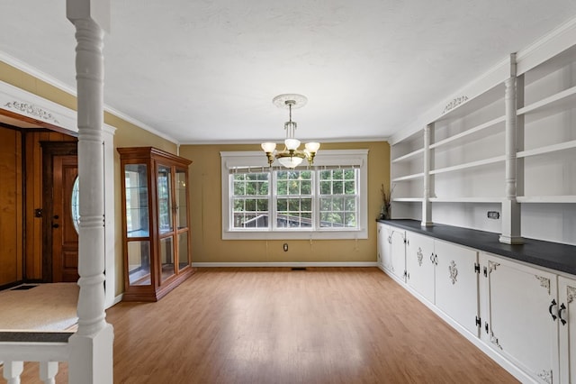 16 Hollow Springs Rd, Blue Ridge, GA 30513 - unfurnished dining area featuring light wood-style flooring, a chandelier, baseboards, ornamental molding, and built in shelves