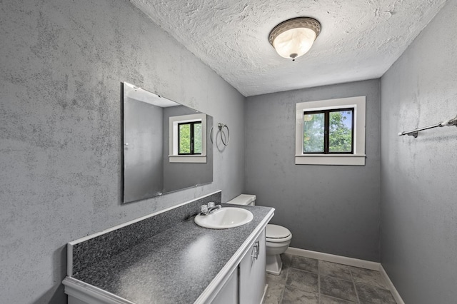 16 Hollow Springs Rd, Blue Ridge, GA 30513 - bathroom with healthy amount of natural light, toilet, vanity, a textured ceiling, and baseboards