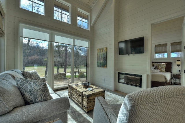 living room with high vaulted ceiling and a healthy amount of sunlight