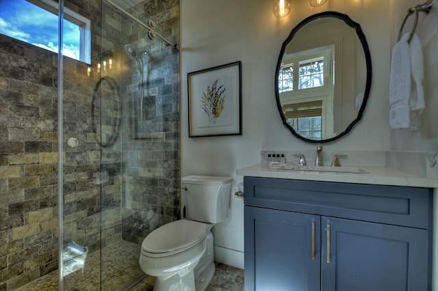 bathroom featuring plenty of natural light, toilet, vanity, and an enclosed shower