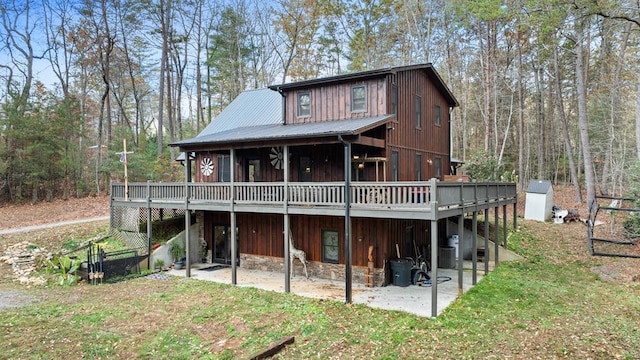 rear view of property featuring a wooden deck, central AC, a patio area, and a lawn