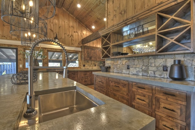 kitchen featuring plenty of natural light, high vaulted ceiling, an inviting chandelier, and sink