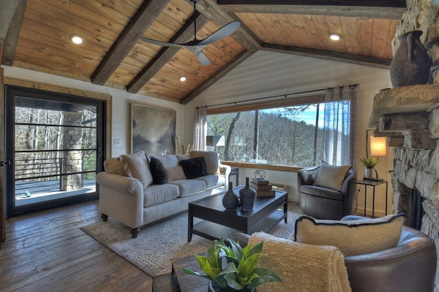 living room featuring ceiling fan, beam ceiling, wooden ceiling, and a stone fireplace