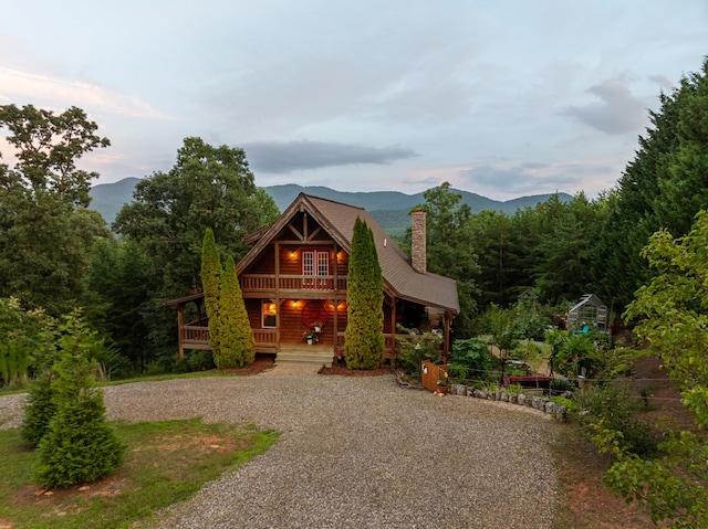 log-style house featuring a mountain view and covered porch