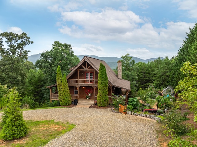 log cabin featuring a porch and a mountain view