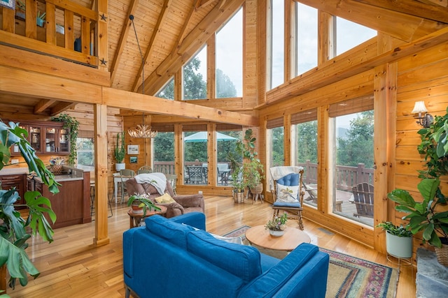 sunroom / solarium with vaulted ceiling with beams, wood ceiling, and a healthy amount of sunlight