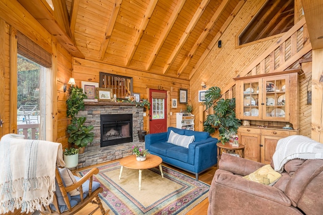 living room with a stone fireplace, beamed ceiling, wood walls, and hardwood / wood-style floors