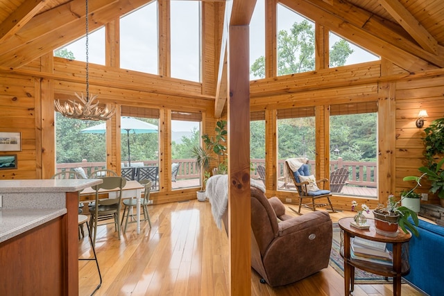 living room featuring high vaulted ceiling, wood ceiling, beam ceiling, and light hardwood / wood-style floors