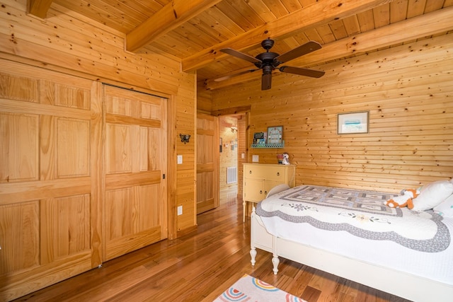 bedroom with beam ceiling, ceiling fan, and hardwood / wood-style flooring