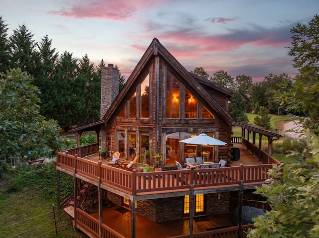 back house at dusk featuring a deck