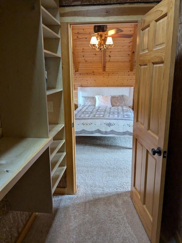 unfurnished bedroom featuring light colored carpet and wood walls