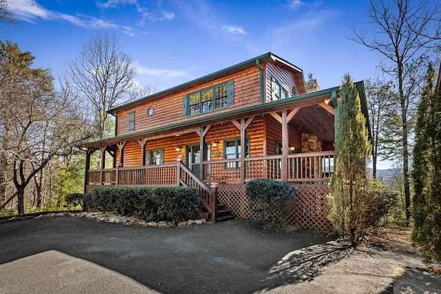 view of front facade featuring a porch and faux log siding