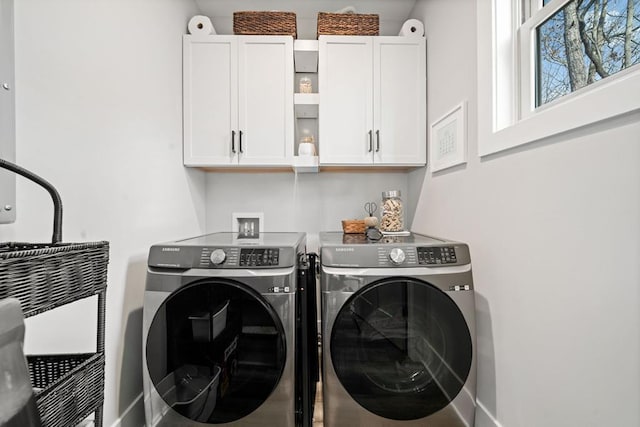 laundry room featuring washer and clothes dryer and cabinets