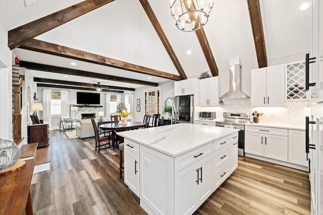 kitchen featuring a kitchen island, pendant lighting, white cabinetry, stainless steel appliances, and wall chimney exhaust hood