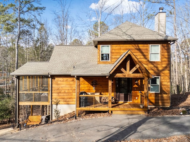 log-style house featuring a sunroom